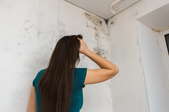 A woman looks at mold.