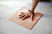 hand on a square of porcelain tile