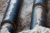 insulated gas pipes in a dirt trench