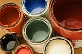 Several cans of paint with the lids off.