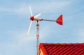 small red and white wind turbine on red roof