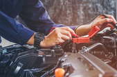 hands checking power in vehicle engine