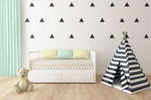 A kid's room with triangles stenciled on the wall.