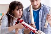 woman and man fixing chair legs with caulk