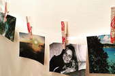 A garland of photos held on a string with decorated clothespins. 