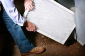 person replacing a furnace filter