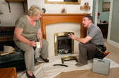 A certified technician speaking to an older homeowner about her fireplace.