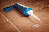 clear silicone caulking spilled on tile floor