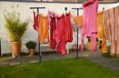 A clothesline in an urban backyard with clothes hanging to dry.
