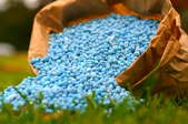 Blue fertilizer in brown paper bag.