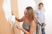 female male couple painting a wall