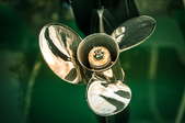 silver boat propeller attached to green boat