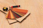 array of laminate faux-wood flooring options, boards, and tools