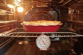 pie in oven with thermometer and light