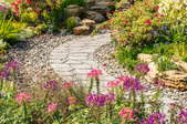 flagstone pathway in flower garden with river rocks
