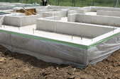 A concrete slab foundation with houses in the background.