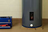 A water heater next to a tool box.