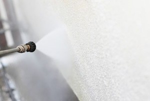 pressure washer cleaning a stucco wall