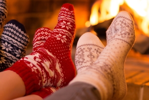 Feet lined up in front of a fireplace