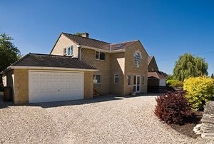 A house with a mixed gravel driveway.