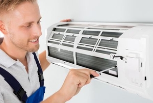 A man works on an AC unit.