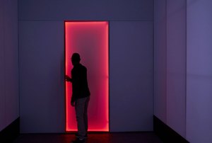 a person opening a door with red lighting