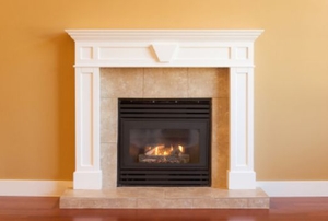 An elegant gas fireplace set into a wall with a marble hearth.