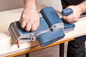 Carpenter with electric plane.