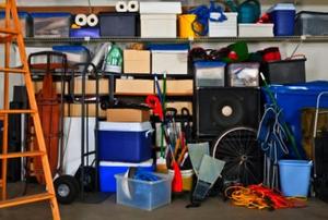 Storage containers on shelves in a garage, with odds and ends scattered about.
