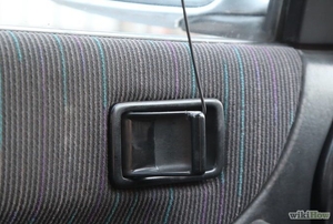 A coat hanger being used to open a locked car door handle.