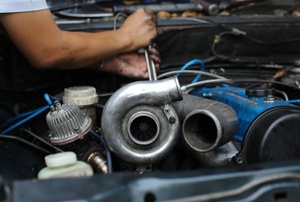 A man works on a turbo diesel engine.