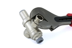 A pressure regulator is being adjusted with a wrench.