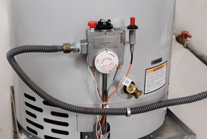 The controls of a hot water heater on a metal platform.