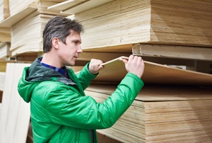 a person in green looking through plywood