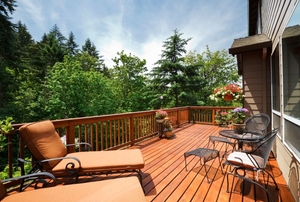A stained deck in a sunny backyard.