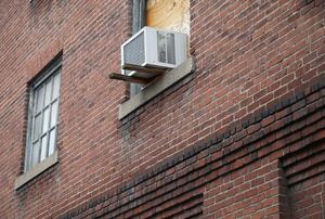 air conditioner mounted in window on brick facade