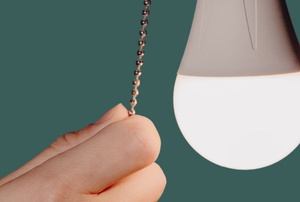 hand pulling chain switch near light bulb
