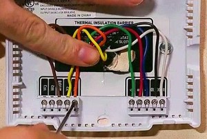 hand tinkering with heating panel wiring