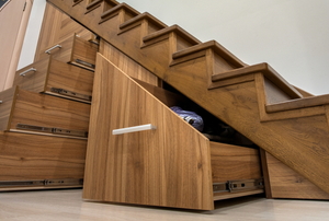 set of drawers and cabinets under wooden stairway