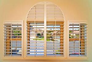 Looking out of louvered slats on a suburban street.