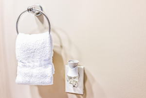 Towel on towel rack next to air freshener in an outlet