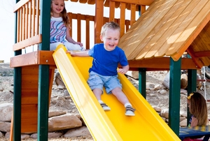 A kid going down a slide on playground equipment