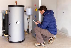 Man kneeling next to a water heater