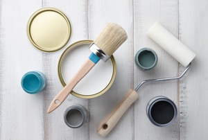 A collection of paint cans and paint tools.
