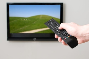Pointing a remote at a wall-mounted flat screen TV