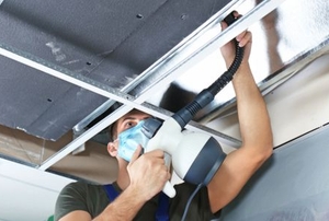 A man works on an air duct.