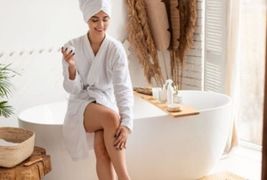 smiling woman in robe on bathroom tub