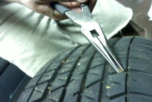 a pair of pliers in front of a tire