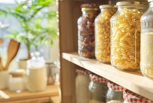clean, organized pantry with jars of food, plants in the background
