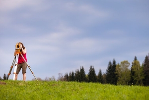person using a survey level in a field